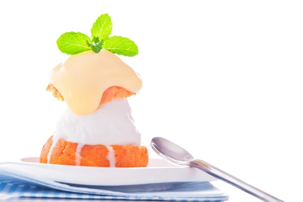 Içinde dondurma vanilya sosu ve mı ile küçük bir tabak profiterol — Stok fotoğraf