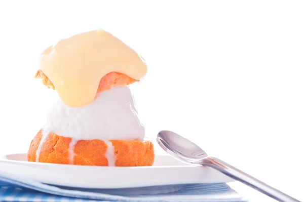 Профитерол в маленькой тарелке с ванильным соусом мороженого на w — стоковое фото