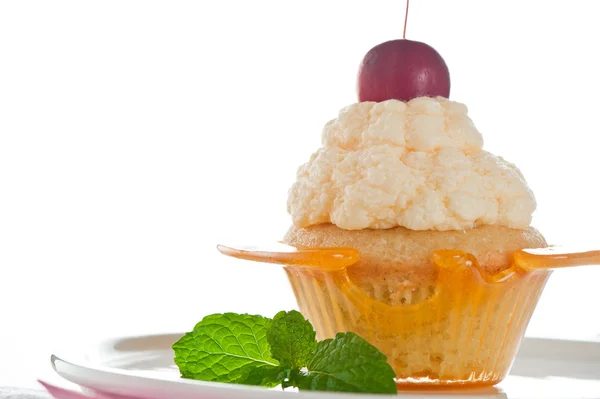 Un cupcake in una tazza di caramello con crema alla vaniglia su dorso bianco — Foto Stock