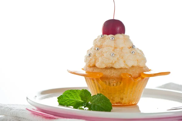 Een cupcake in een kopje van karamel met vanille-crème op witte backgr — Stockfoto