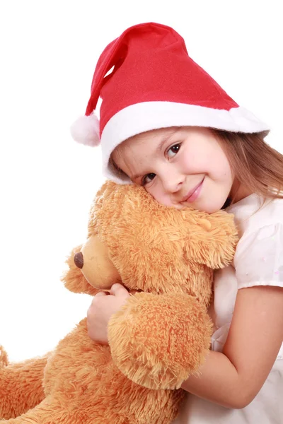 Santa's hat, little girl and a fluffy toy Royalty Free Stock Photos