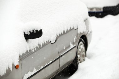 Cars covered with snow after a heavy snowfall in a city clipart