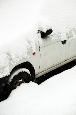 Cars covered with snow after a heavy snowfall in a city clipart