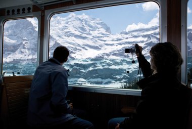 Tourists staring at a glacier in high alps in Switzerland clipart