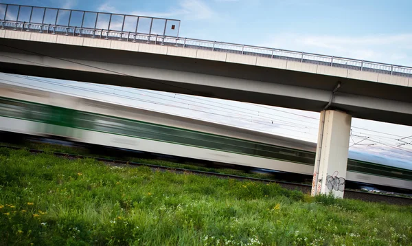 Fast train going swiftly through summer landscape and passing un — Stock Photo, Image