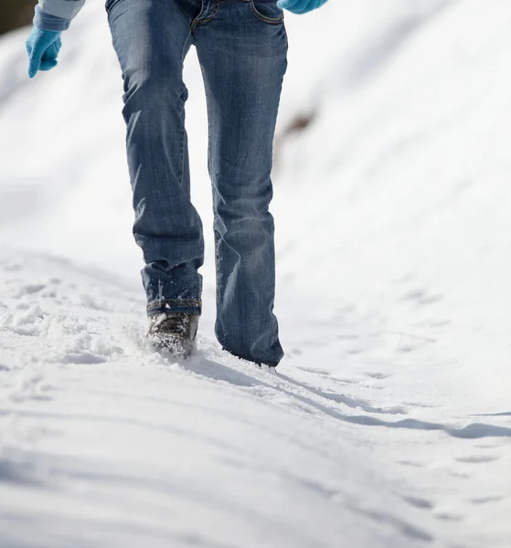 Pretty young woman walking in deep snow on a sunny winter day — Stock Photo, Image