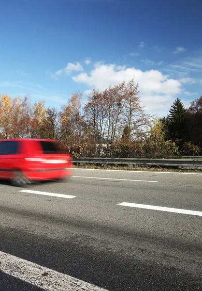 Speeding concept - Car moving fast on a highway on a lovely autu — Stock Photo, Image