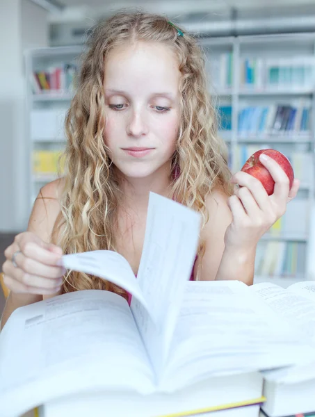 Bonita estudiante universitaria en una biblioteca — Foto de Stock