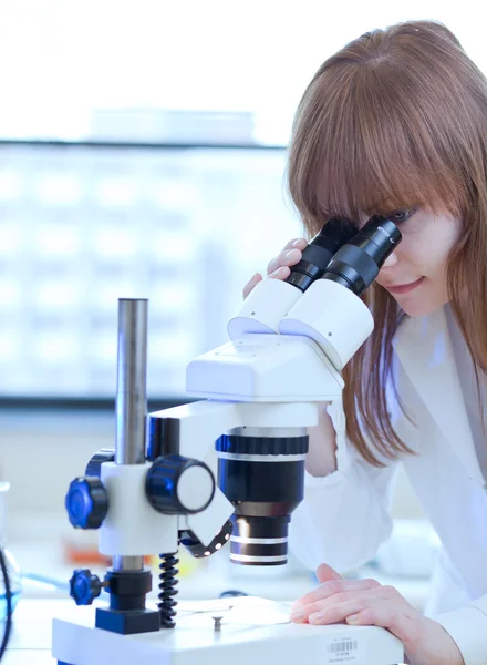 Güzel kadın araştırmacı laboratuarda mikroskop kullanma — Stok fotoğraf