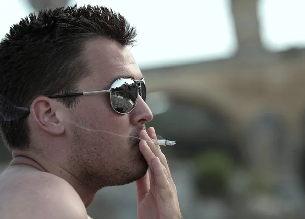 Todfeindliche Angewohnheit - männlicher Raucher mit Sonnenbrille raucht eine Zigarette — Stockfoto
