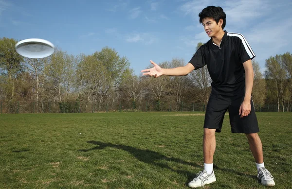 Jongeman speelt frisbee in het park — Stockfoto