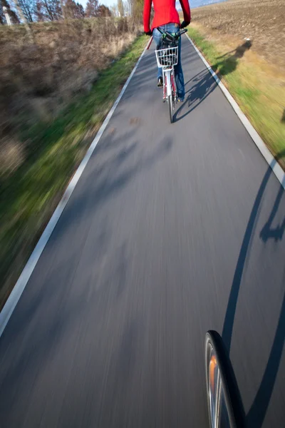 Cykloturistika - mladá žena, jízda na kole do práce (je obraz pohybu blurre — Stock fotografie