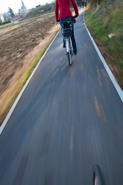 Велосипед - молодая женщина на велосипеде на работу (изображение движения размыто — стоковое фото