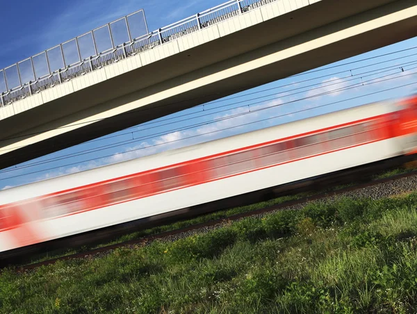 Snelle trein passeren onder een brug op een mooie zomerdag (beweging — Stockfoto