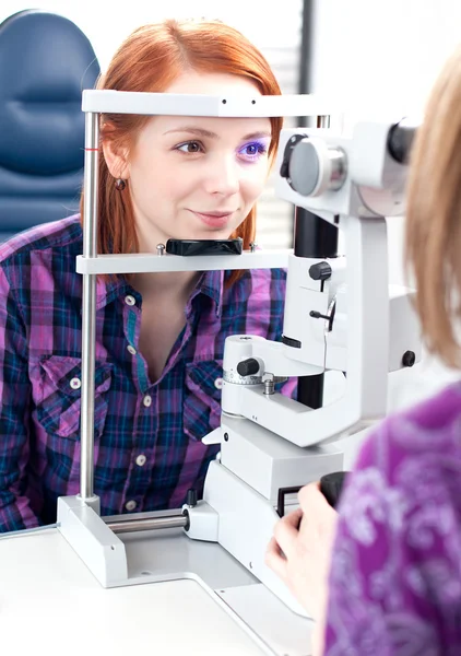 Концепция оптометрии - красивая молодая женщина с осмотром глаз — стоковое фото