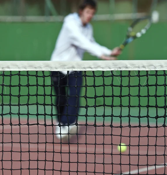 Tennisspeler in actie (selectieve aandacht, focus op het net) — Stockfoto