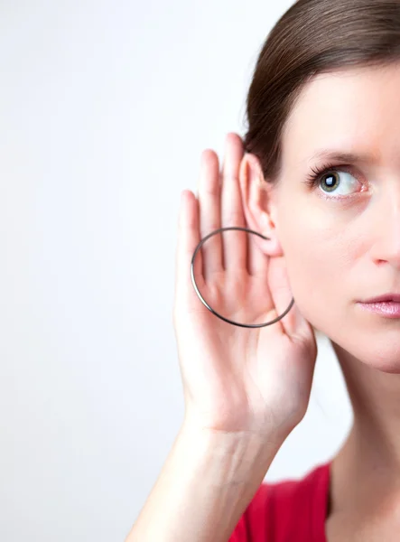 Mujer joven y bonita pone su mano en su oído y escucha attentiv — Foto de Stock