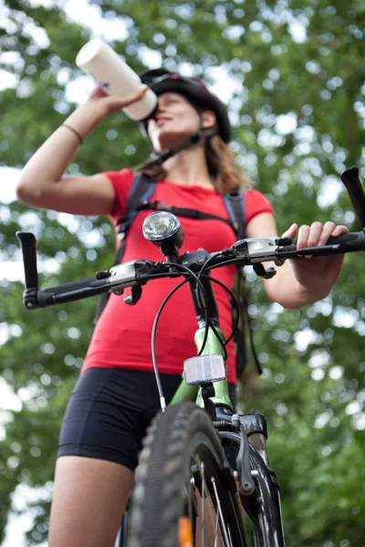 Hübsche junge Radfahrerin überflügelt auf ihrem Mountainbike (flach — Stockfoto
