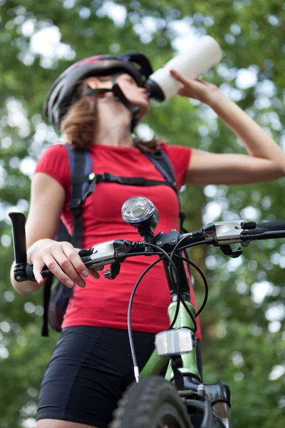 Досить молода жінка-велосипедистка на своєму гірському велосипеді (неглибока — стокове фото