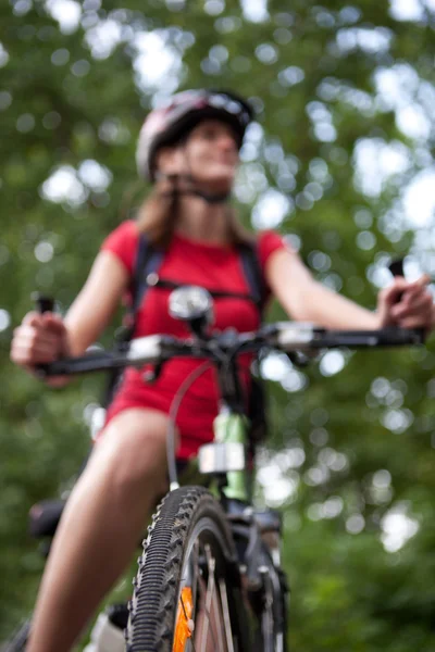 Hübsche junge Radfahrerin überflügelt auf ihrem Mountainbike (flach — Stockfoto
