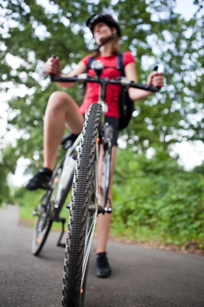 Ganska ung kvinnlig MC outddors på hennes mountainbike (grunt — Stockfoto