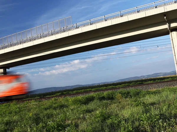 Γρήγορο τρένο που διέρχεται κάτω από μια γέφυρα — Φωτογραφία Αρχείου