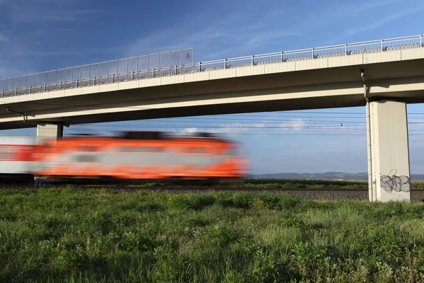 Snelle trein passeren onder een brug — Stockfoto