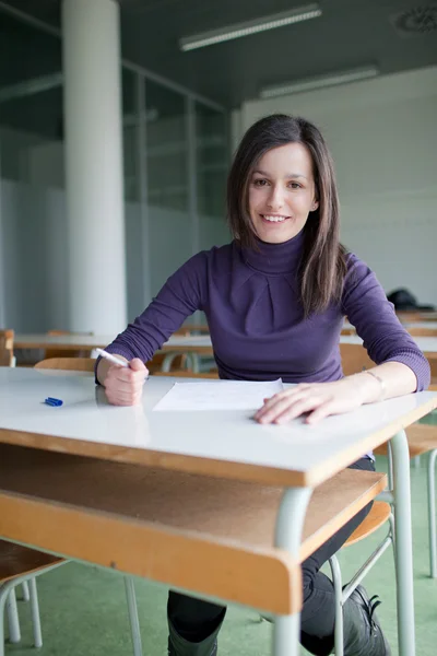 Porträt einer hübschen Studentin, die in einem Klassenzimmer arbeitet — Stockfoto