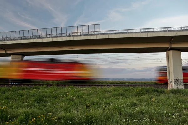 Two fast trains meeting while passing under a bridge — Stock Photo, Image
