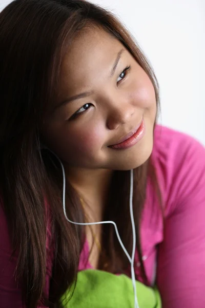 Молода жінка слухає музику, посміхається — стокове фото