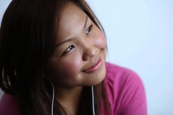 Mujer joven escuchando música, sonriendo — Foto de Stock