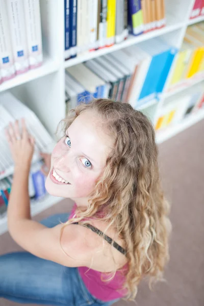 Όμορφη γυναίκα φοιτητής σε μια βιβλιοθήκη — Φωτογραφία Αρχείου