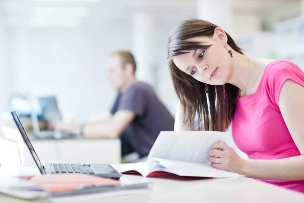 I biblioteket - ganska kvinnlig student med laptop och böcker wor — Stockfoto