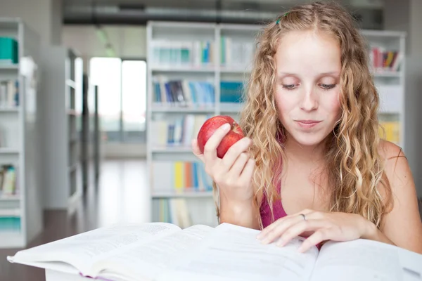 Красивая студентка колледжа в библиотеке — стоковое фото