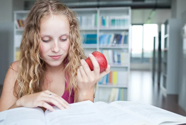 Ganska kvinnliga collegestudent i ett bibliotek (grunt Dof, färg t — Stockfoto