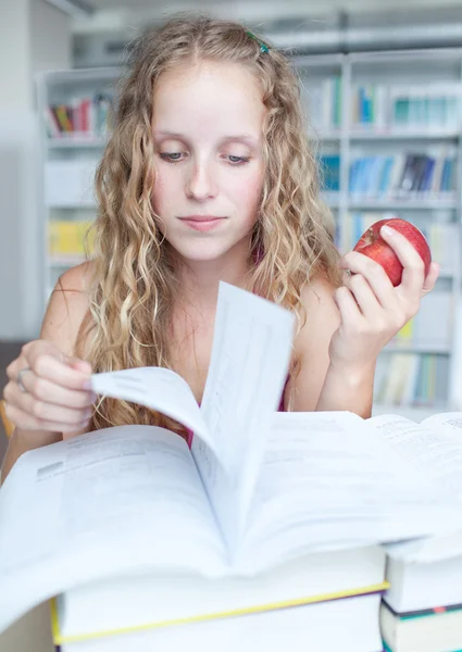 Pretty female college student in a library — Stock Photo, Image