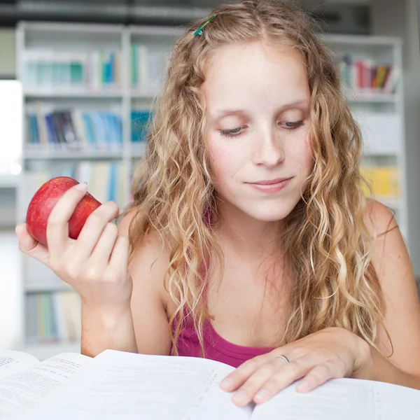 Ganska kvinnliga collegestudent i ett bibliotek (grunt Dof, färg t — Stockfoto