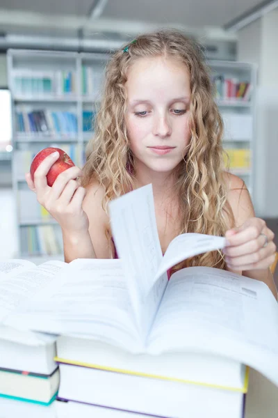 Ganska kvinnliga collegestudent i ett bibliotek — Stockfoto