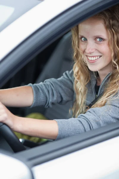 Pretty young woman driving her new car — Stock Photo, Image