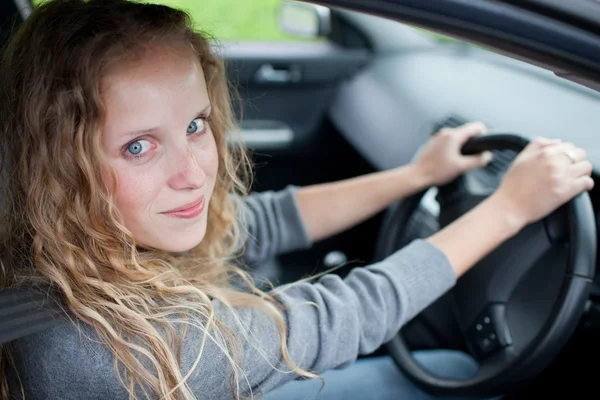 Красивая молодая женщина за рулем своей новой машины — стоковое фото