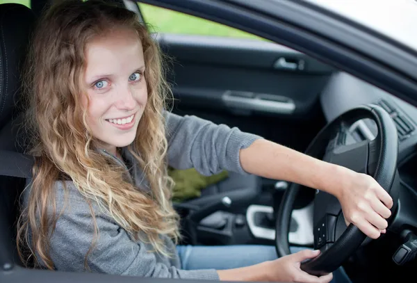 Mujer bastante joven conduciendo su nuevo coche —  Fotos de Stock