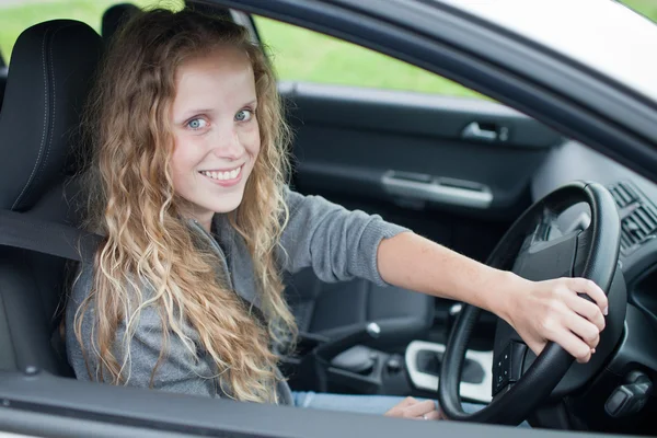 Mujer bastante joven conduciendo su nuevo coche —  Fotos de Stock