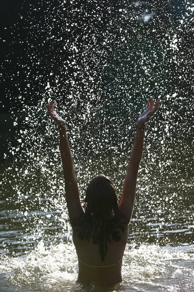 Hermosa joven mujer disfrutando de un baño en un lago / río / mar silhou —  Fotos de Stock