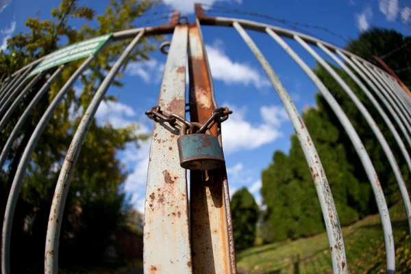 Gate with padlock on a lovely autumn day(intentionally distorter — Stock Photo, Image
