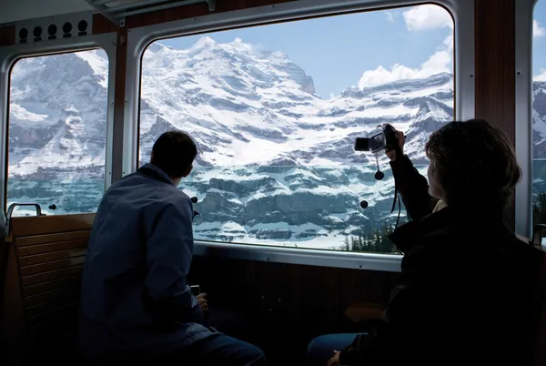 Turistas mirando un glaciar en los altos alpes en Suiza —  Fotos de Stock