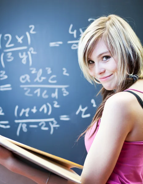 Hezká mladá studentka psaní na tabuli — Stock fotografie