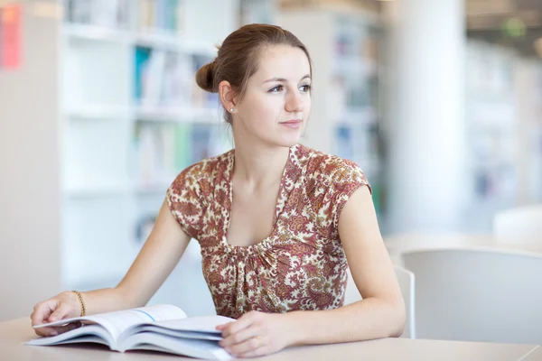 Hezká mladá studentka v knihovně — Stock fotografie