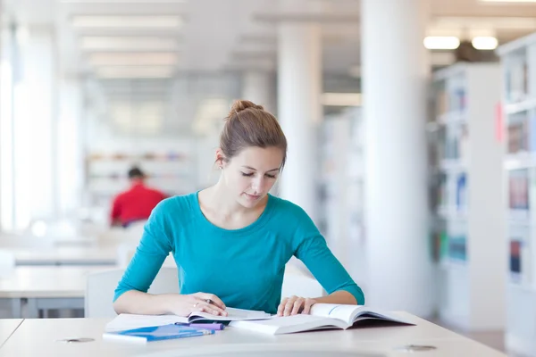 Estudiante universitario bastante joven en una biblioteca — Foto de Stock