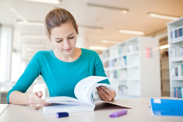 Pretty young college student in a library — Stock Photo, Image