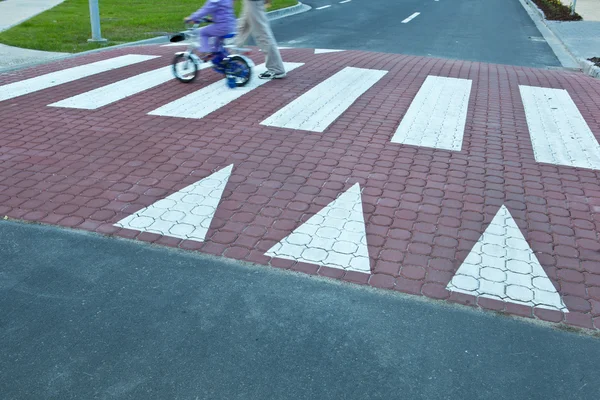 Отец с маленькой девочкой на велосипеде, переходящей улицу (движение bl — стоковое фото